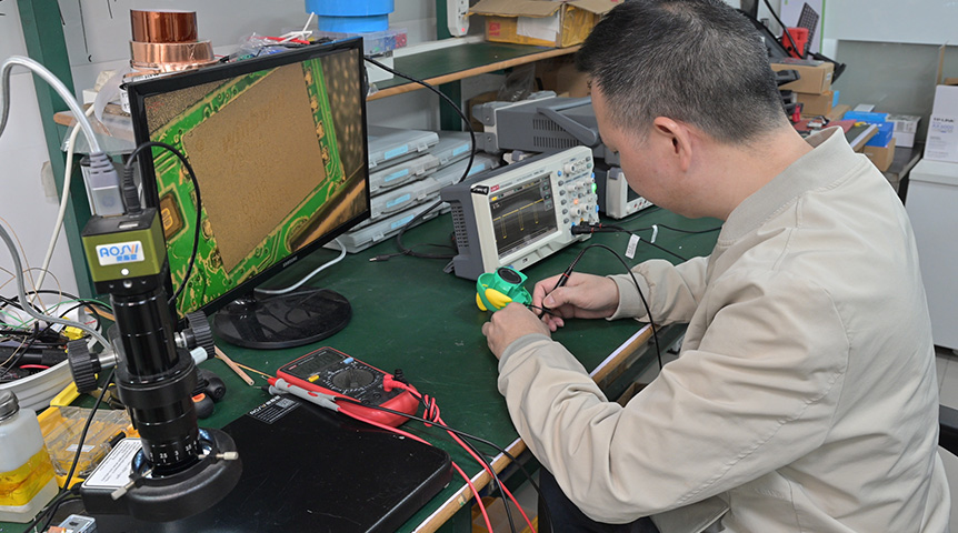 Technician testing a device at an electronics workbench